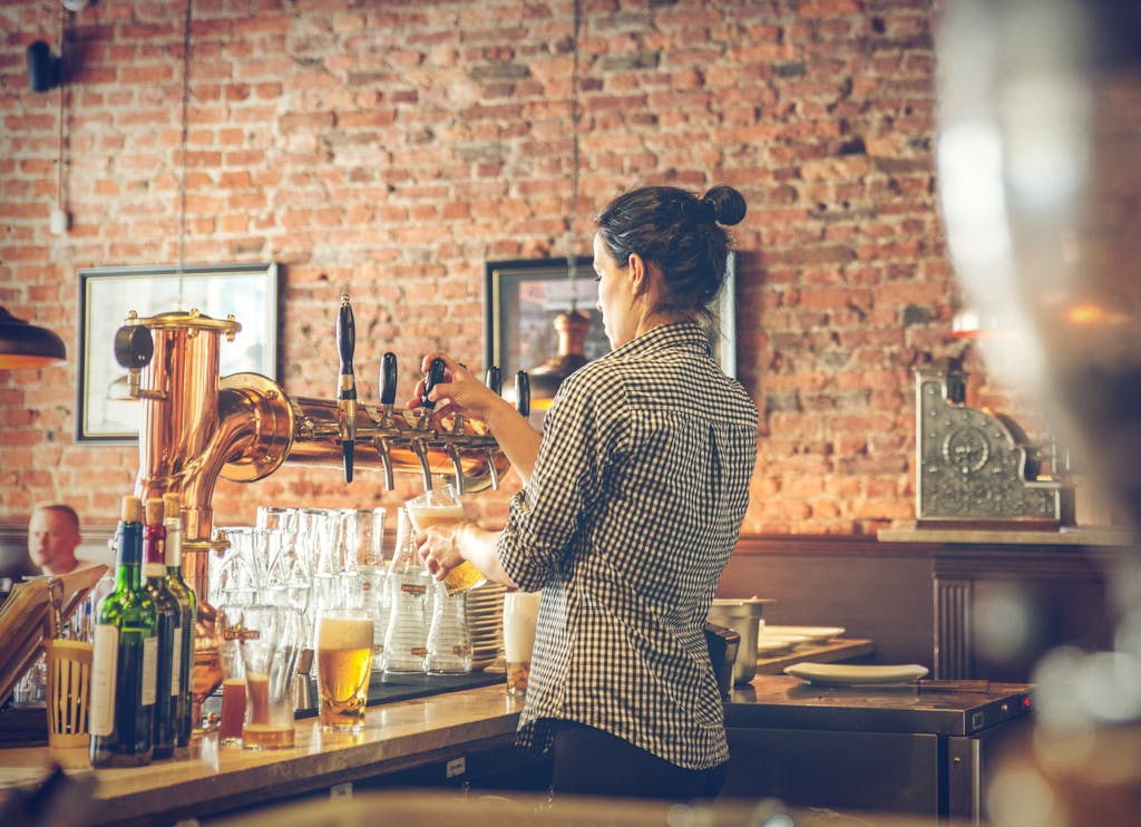 7 Lesbian Travel Secrets Photo of Bartender Pouring Draught Beer