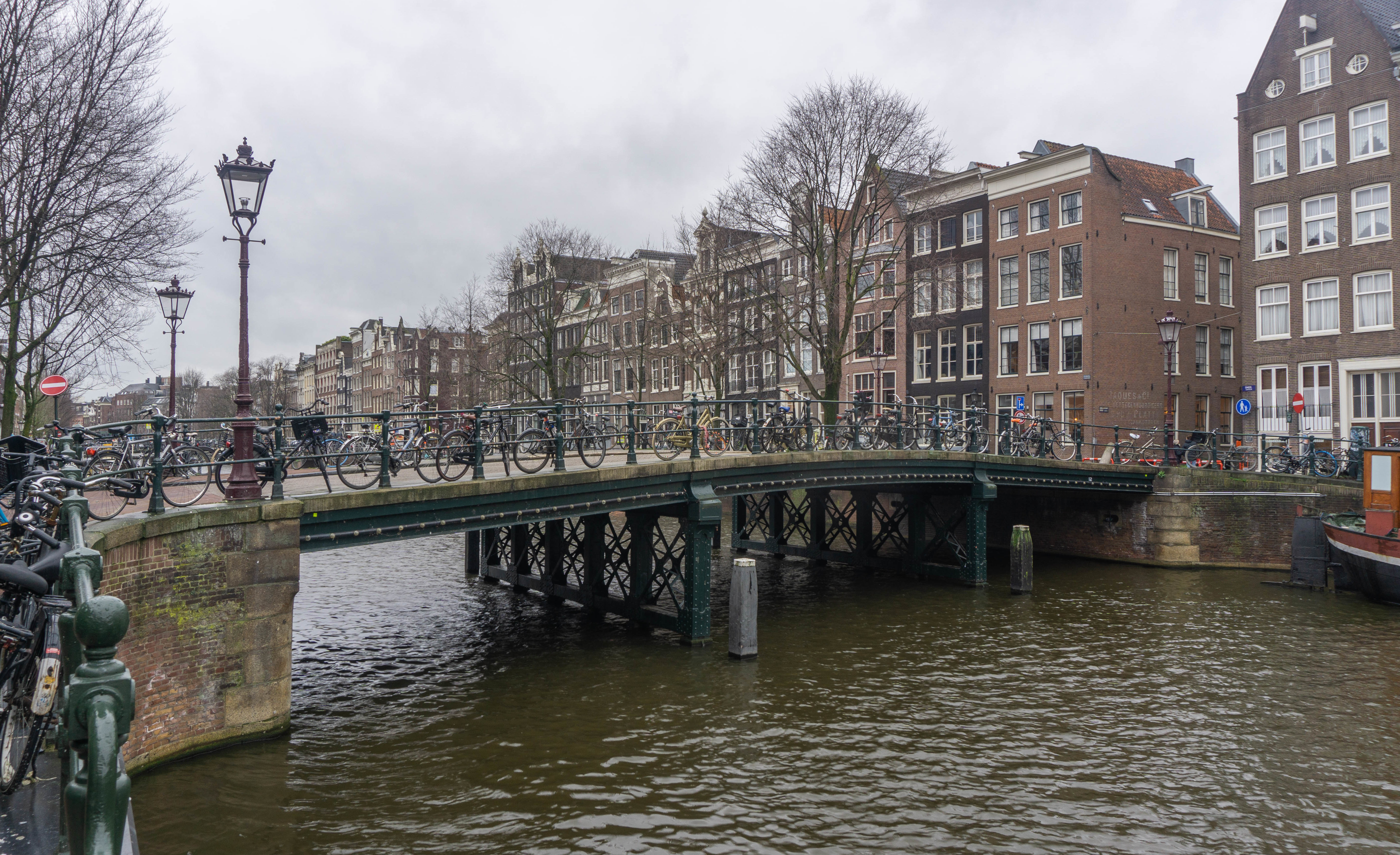 Amsterdam bikes parked along canal bridge - gay Amsterdam travel