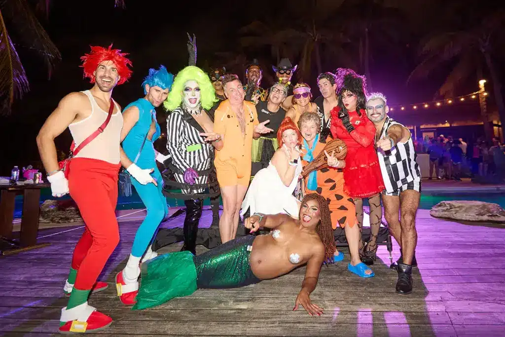 VACAYA guests wearing colorful Halloween costumes at a resort party