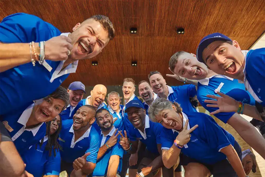 VACAYA V Team hosts smiling together in matching blue shirts